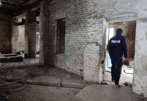 policjantka kontroluje opuszczone pomieszczenia w poszukiwaniu osób narażonych na wychłodzenie