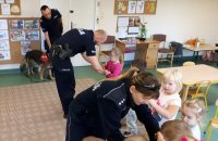 Policjanci ćwiczą z dziećmi jak zachować się w kontakcie z agresywnym zwierzęciem.